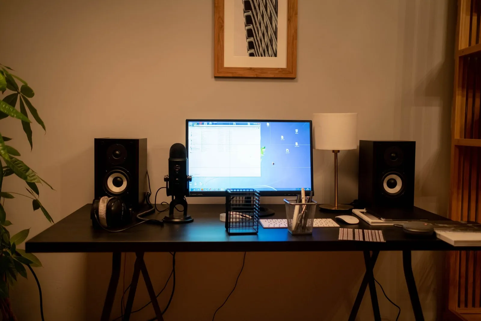A microphone standing on a desk next to a computer