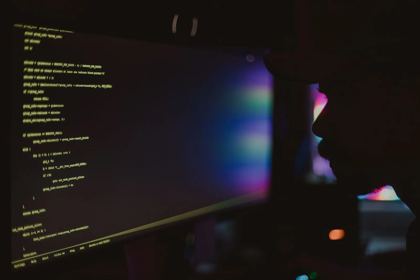 A keyboard in front of a monitor showing lines of source code