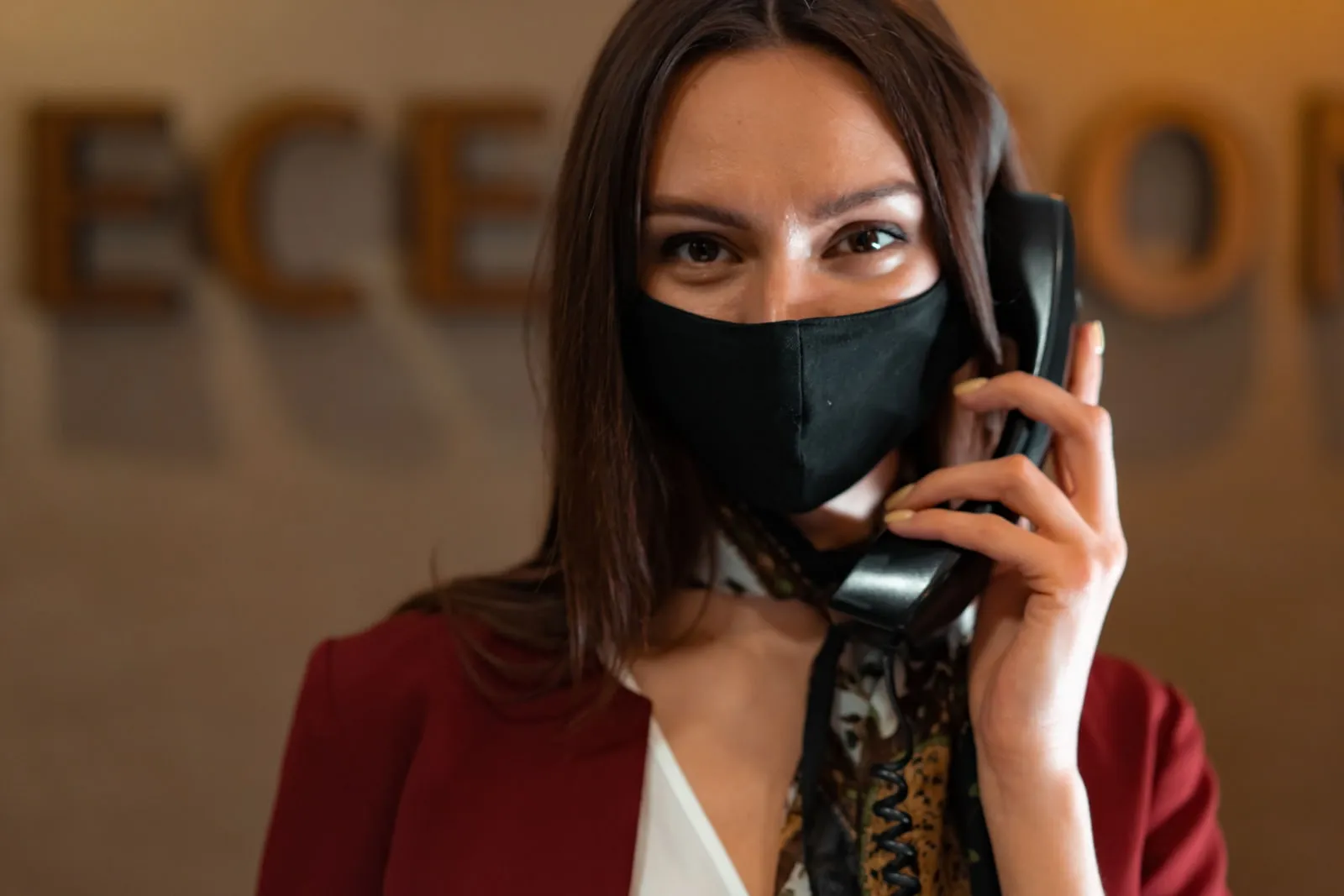 A restaurant host answering a telephone at a counter