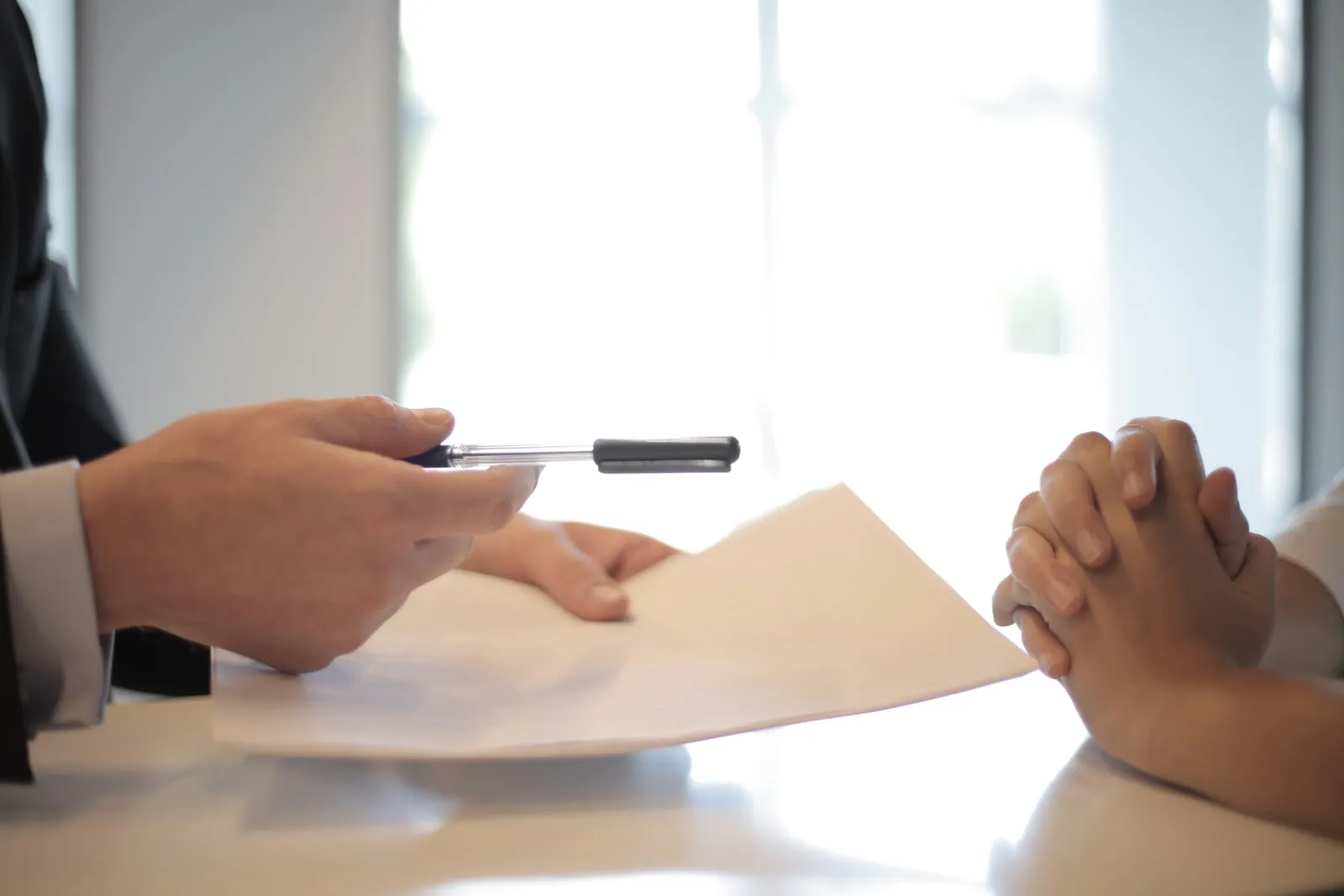 Insurance policy documents and a pen on a desk