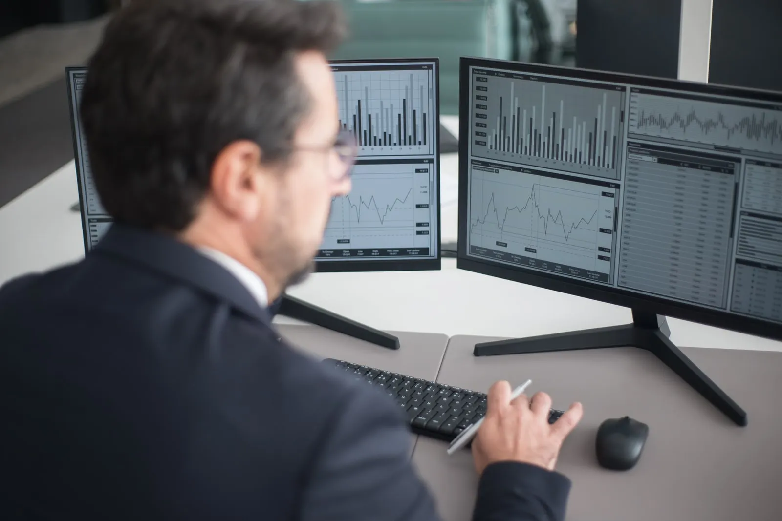 A person working at two computer monitors in an office