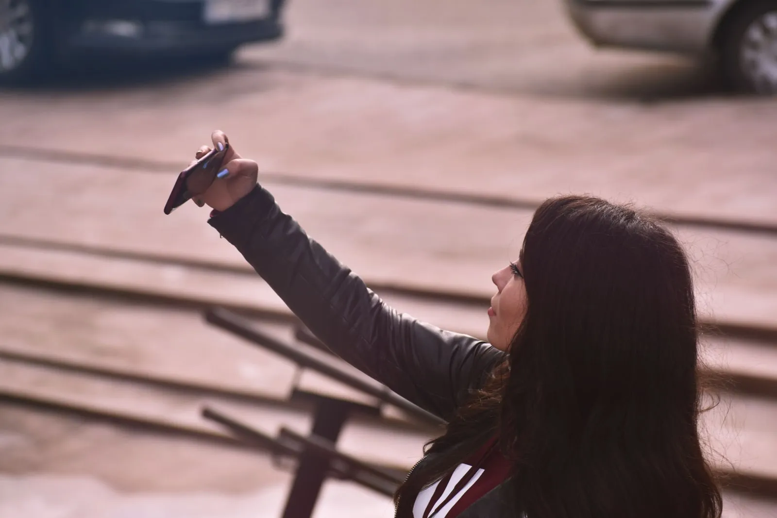 A person taking a photo with a smartphone on a street