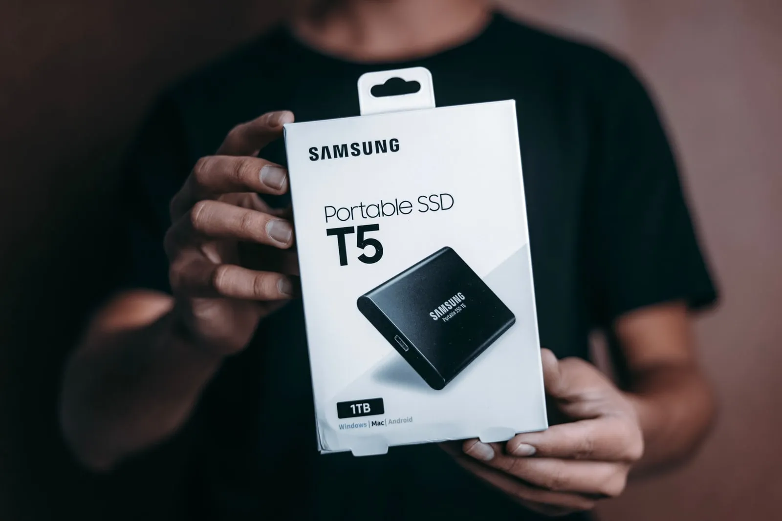 A person holding a boxed portable solid state drive
