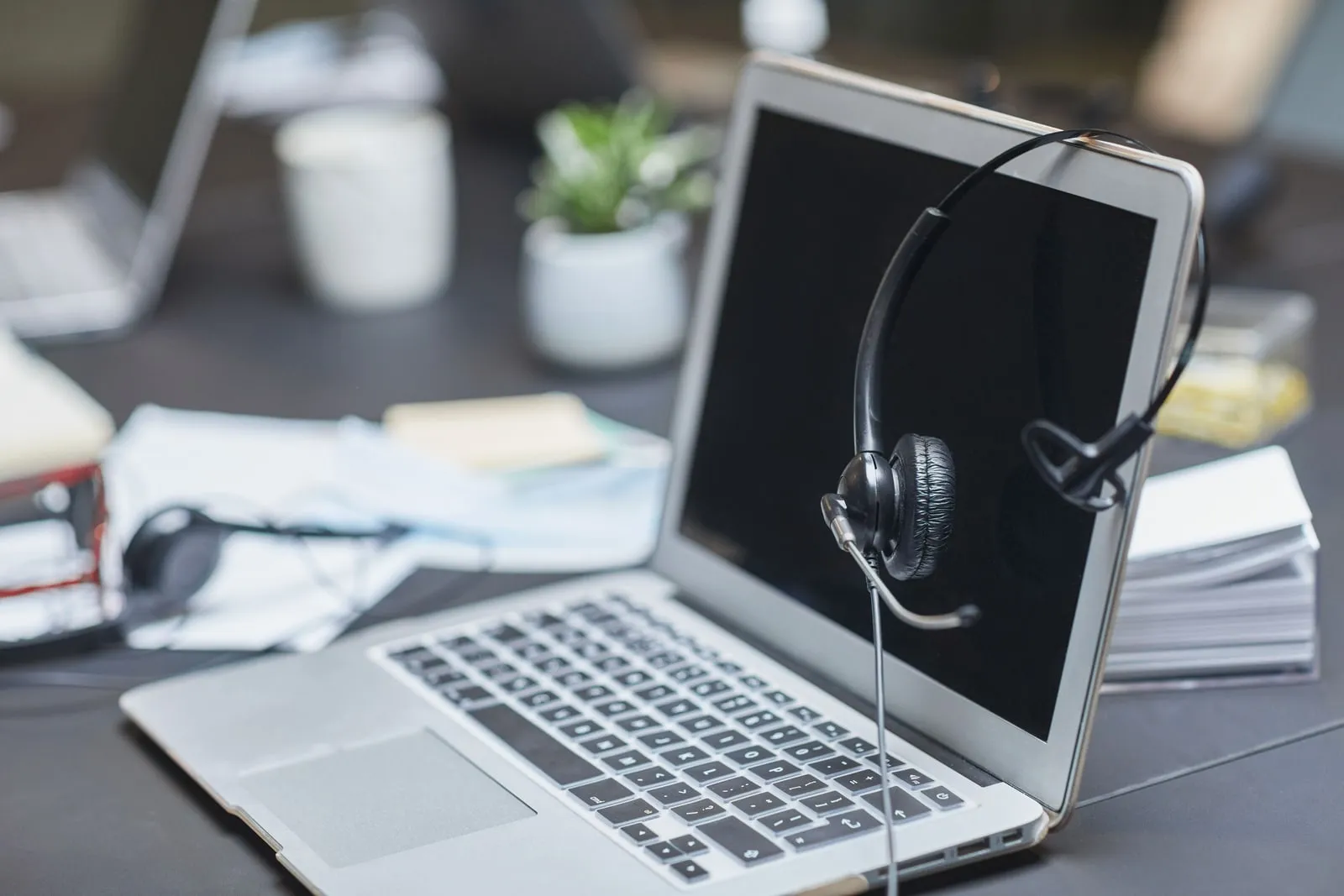 Headphones resting on a desk next to a laptop