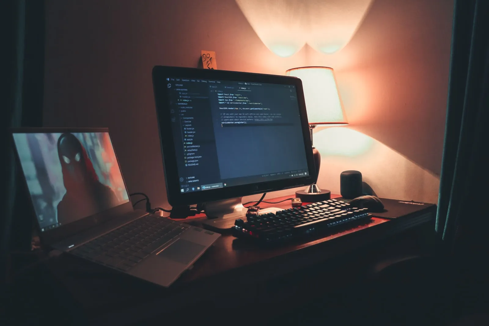 A programmer's desk with several monitors lit up at night