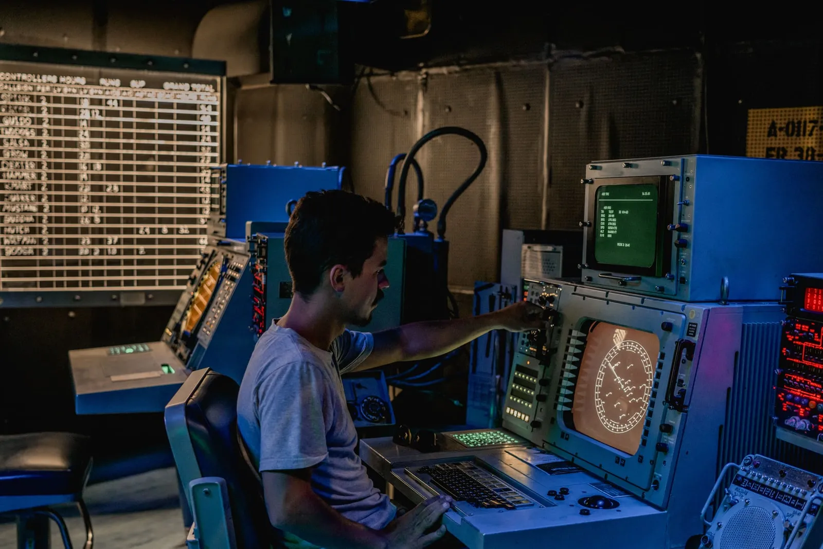A person at a radar console in a dimly lit operations room