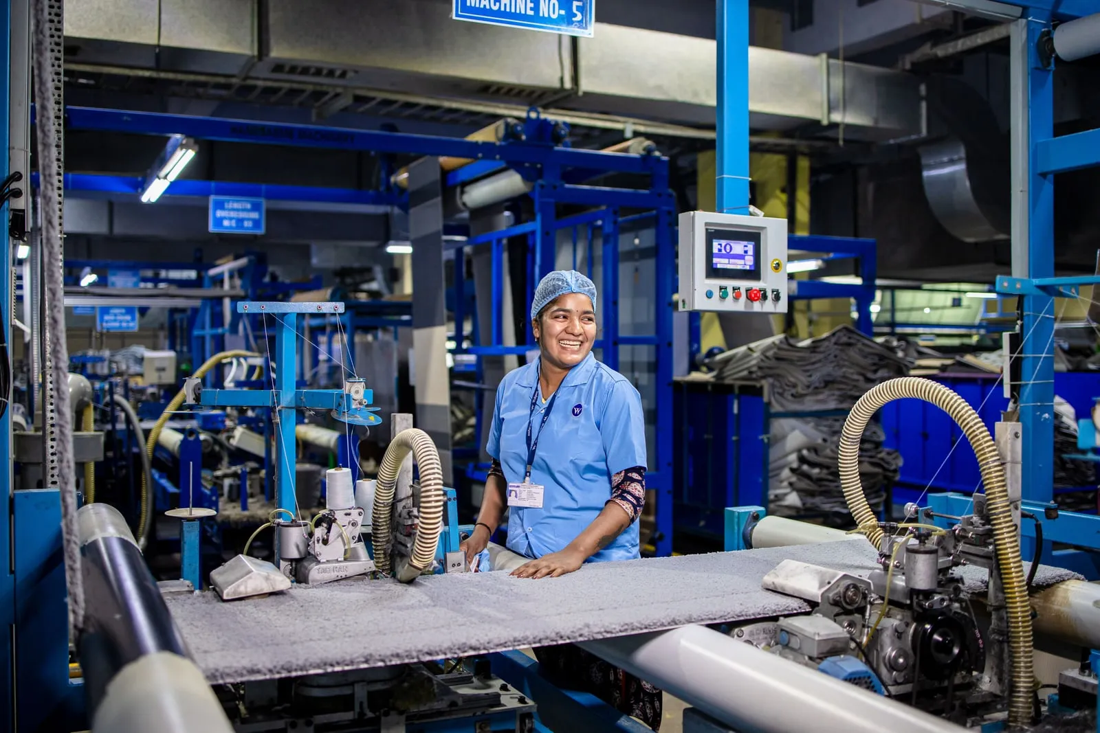 A worker operating a machine on a factory floor