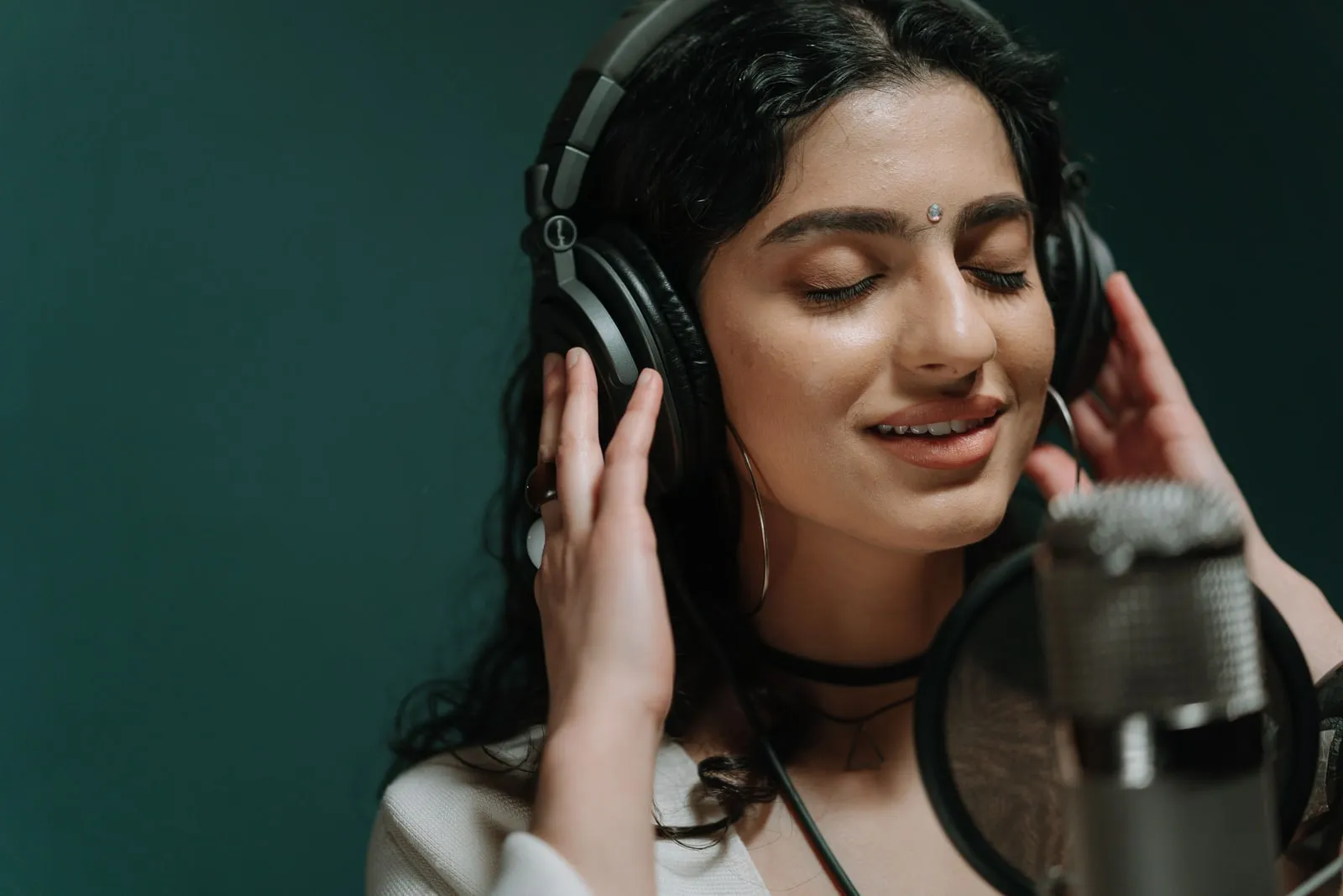 A musician wearing headphones in a recording studio