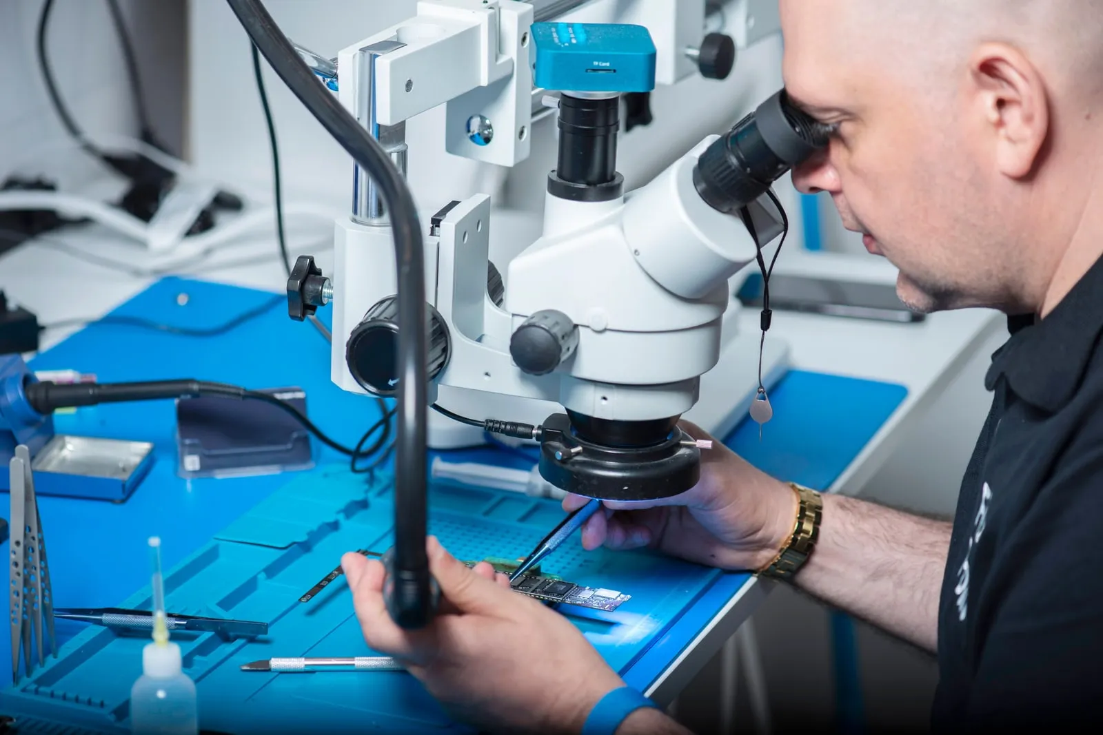 An engineer inspecting electronics on a lab bench