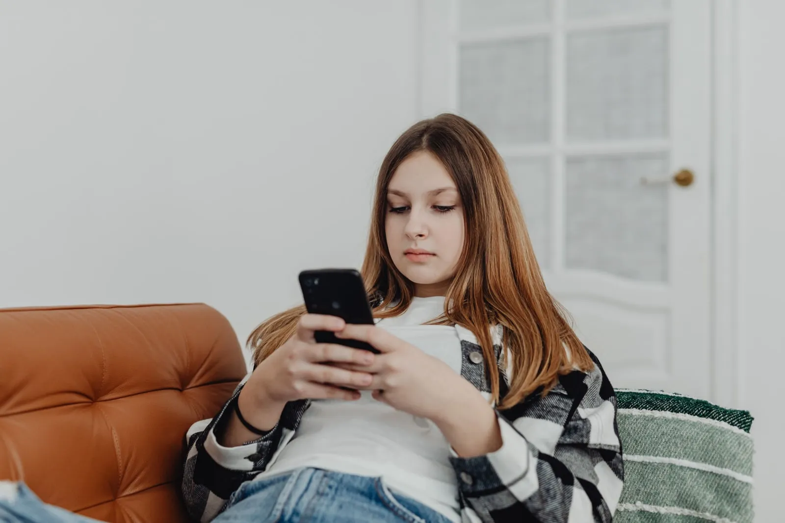 A person using a smartphone on a sofa