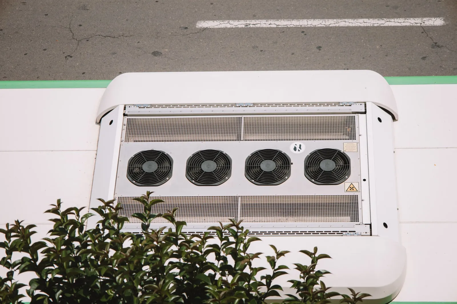 A four-fan cooling unit mounted on a white roof panel