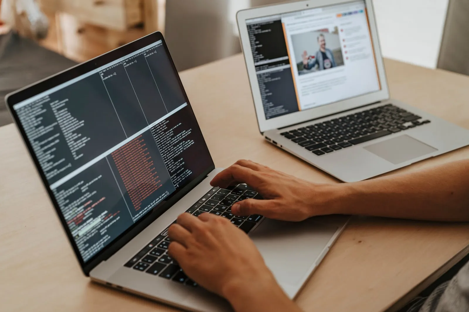A developer typing on a laptop at a desk