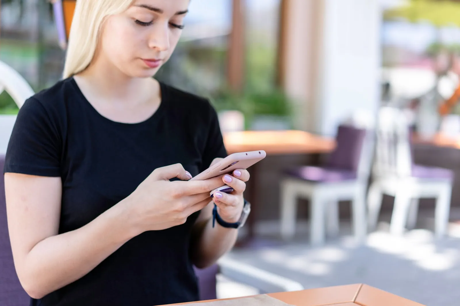 A person using a smartphone at a cafe table