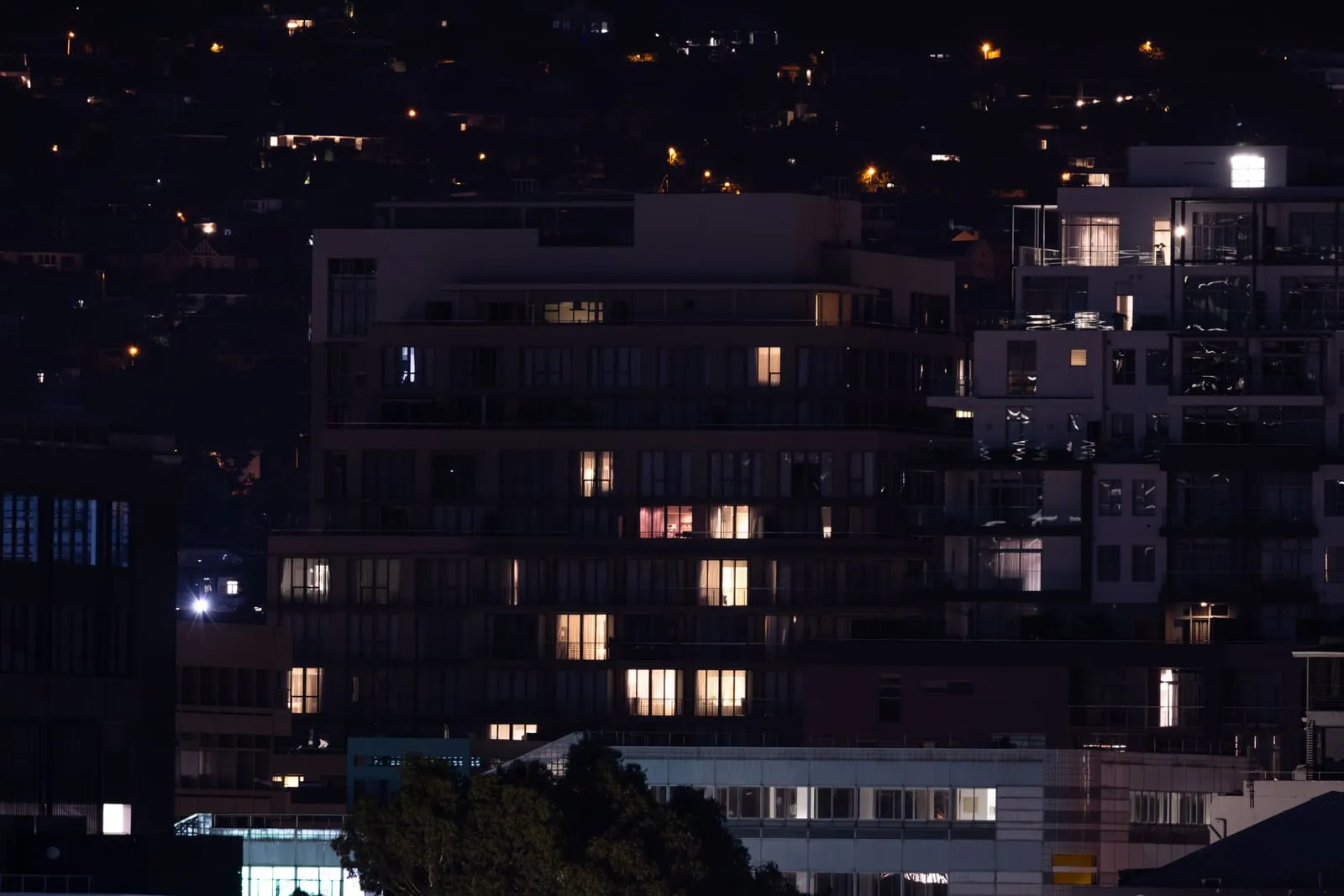 City apartment blocks at night with a few windows still lit