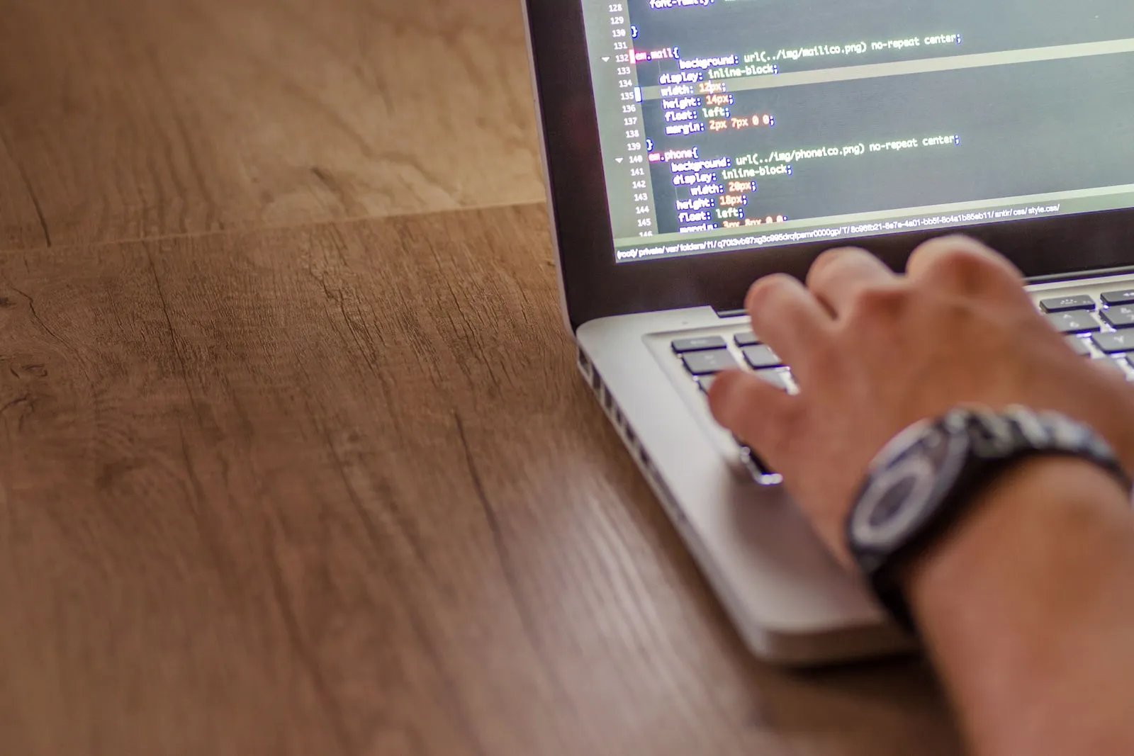 A developer typing code on a laptop screen