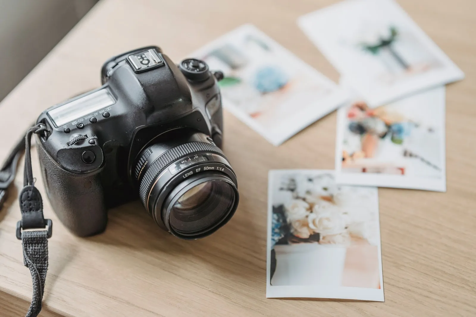 Printed photographs spread across a wooden desk