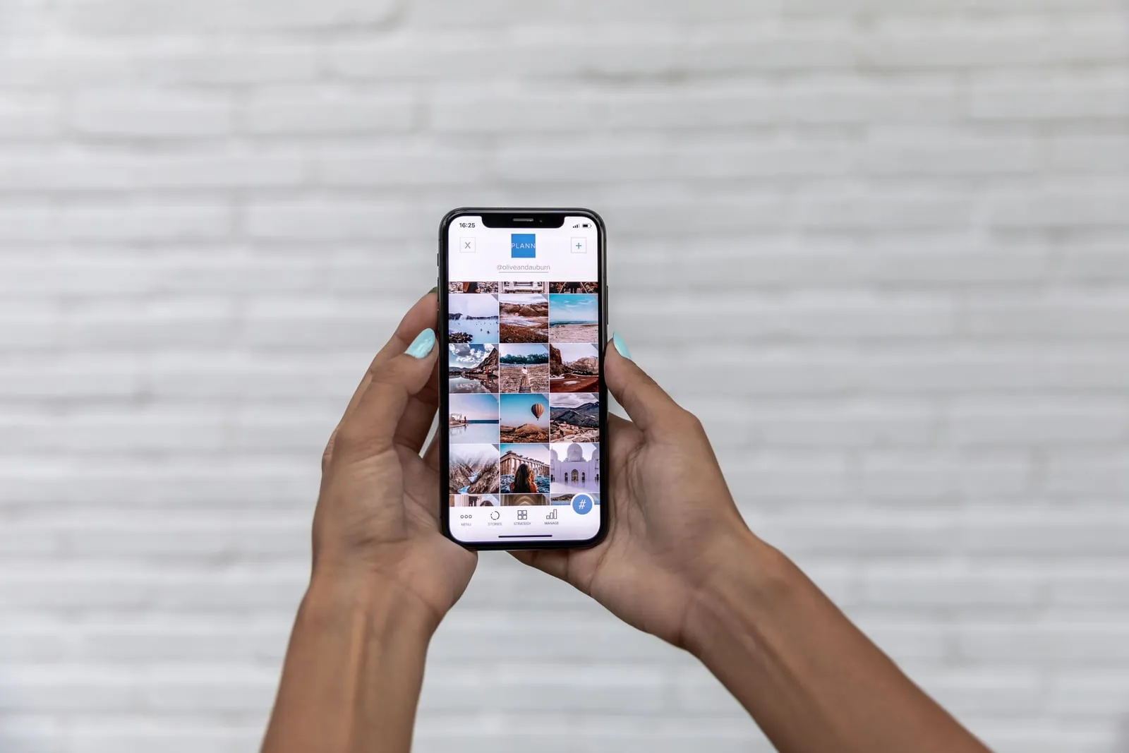 Hands holding a smartphone showing a photo gallery