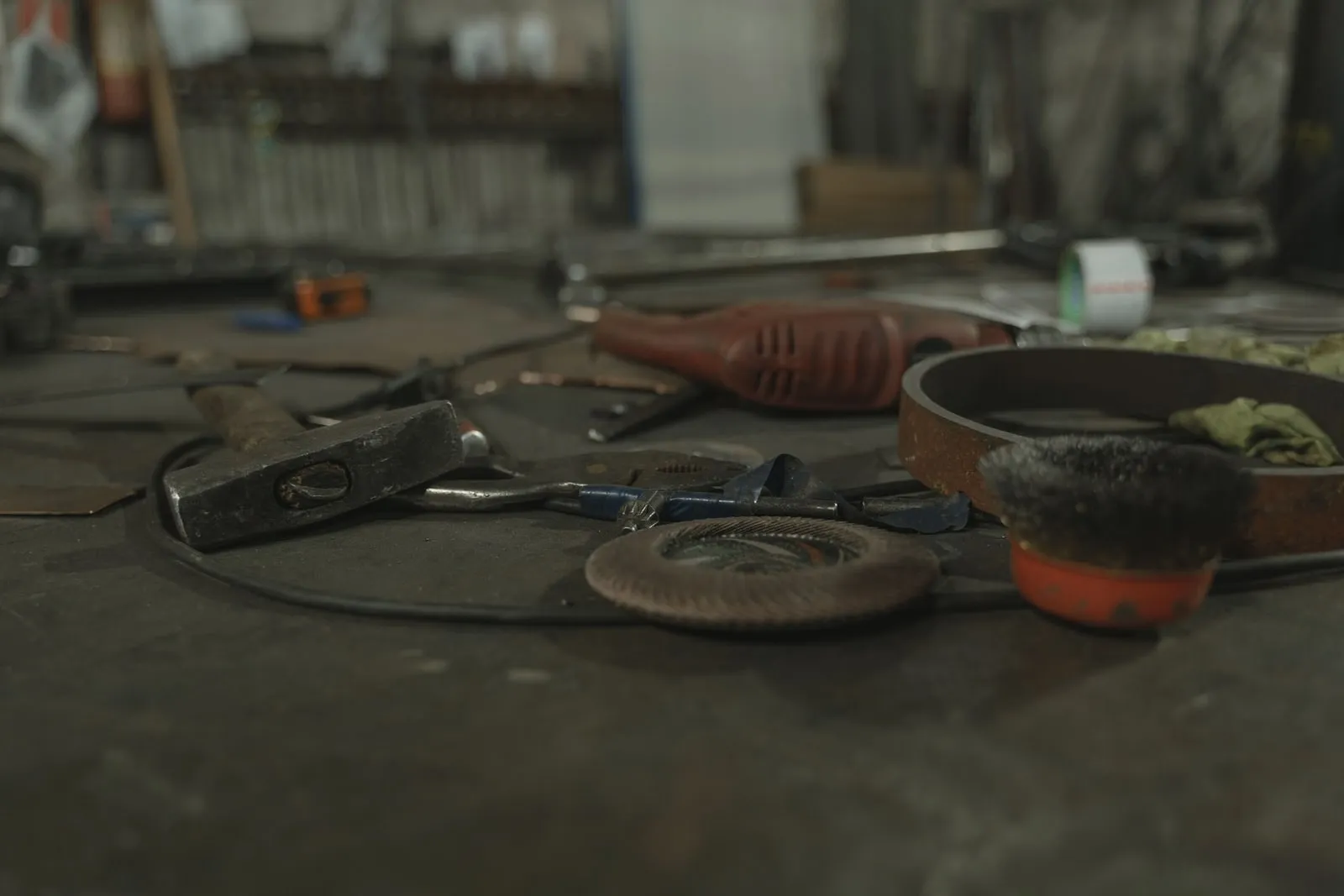 Hand tools and a grinding disc lying on a workshop bench