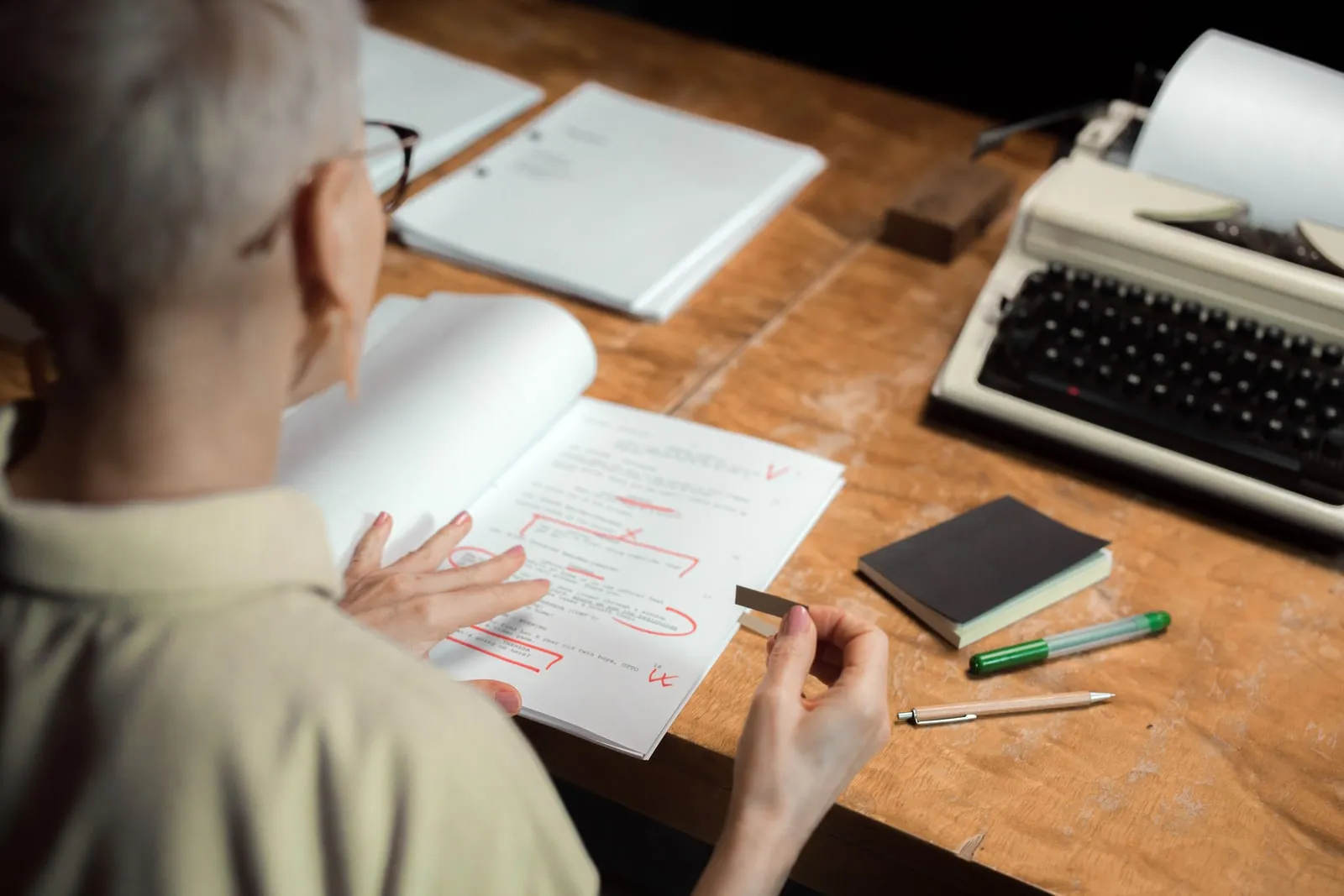 A person marking a printed document with a red pen