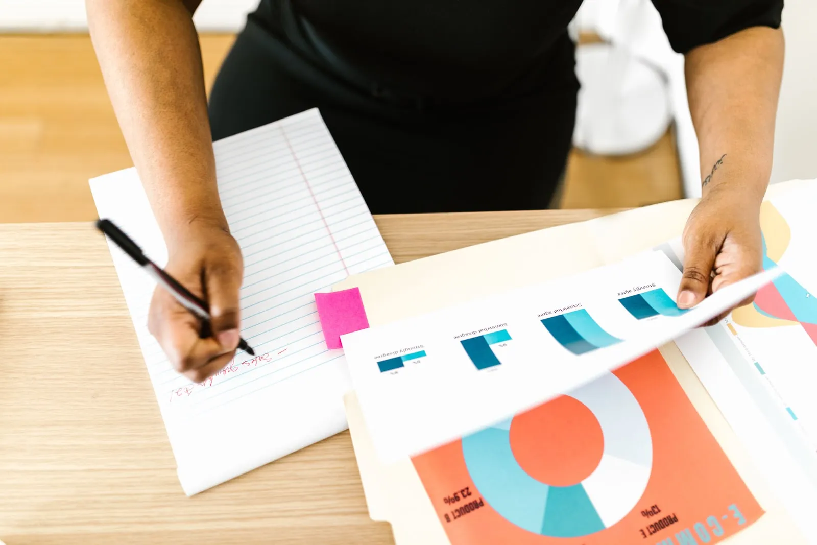A person reviewing printed financial charts at a desk