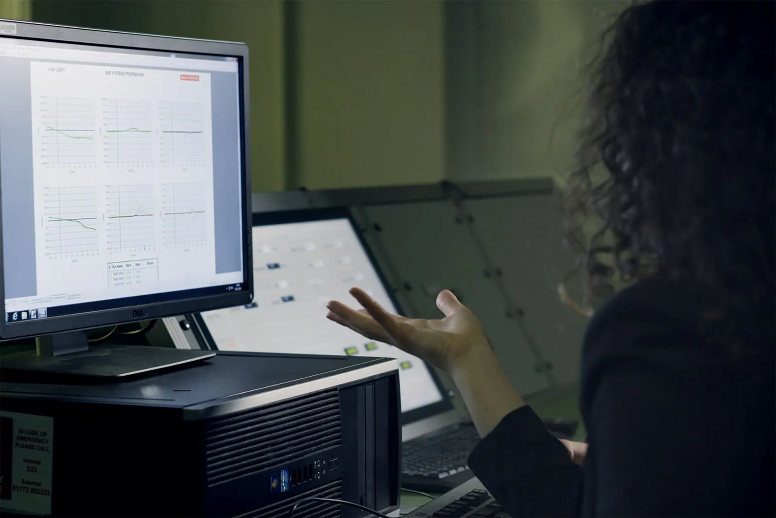 An engineer looking at charts on a monitor