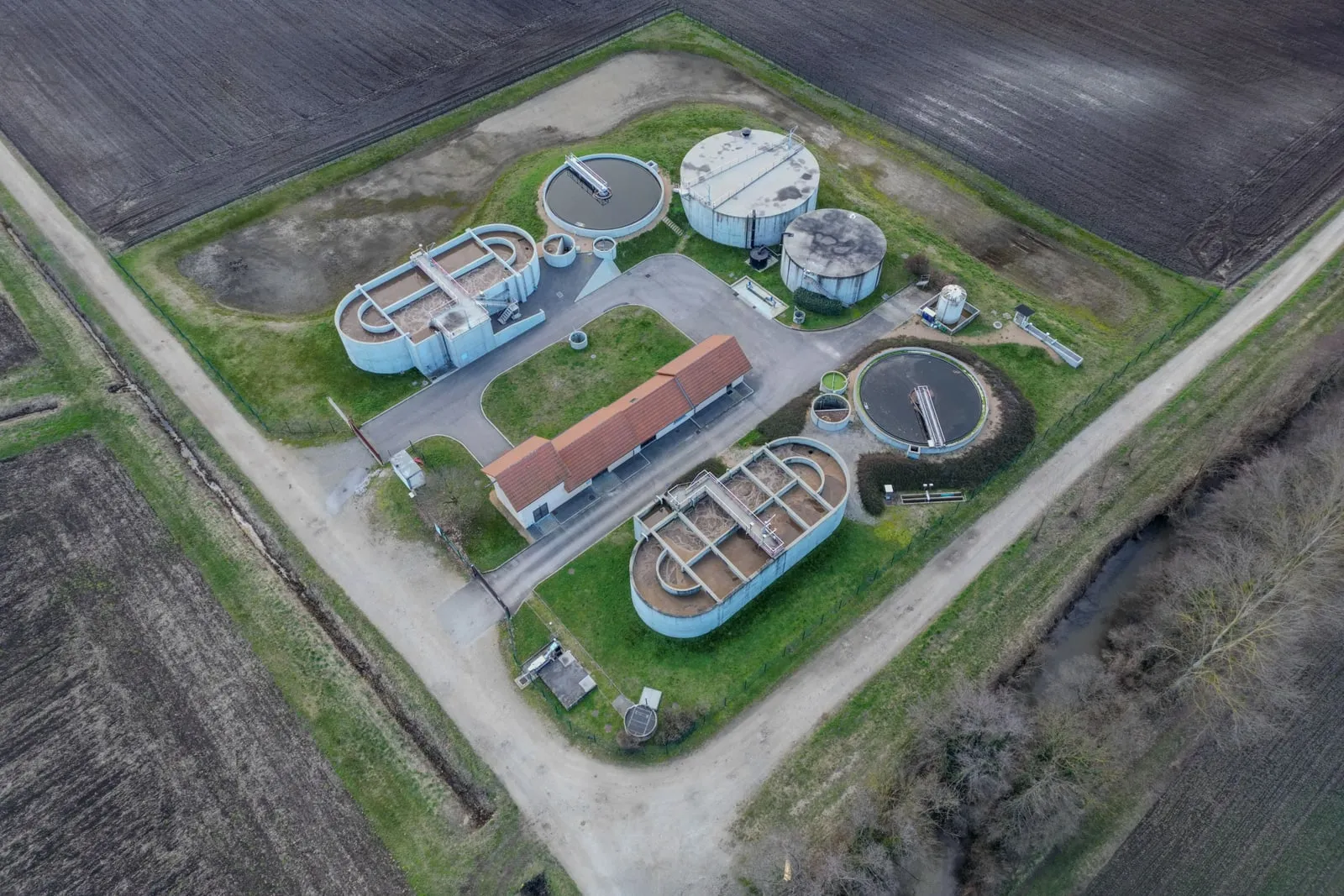 An aerial view of a water treatment plant with circular tanks