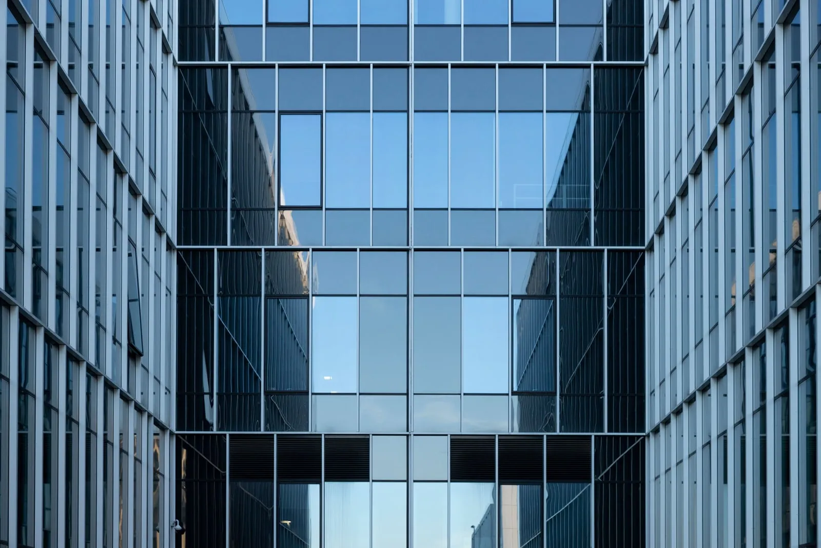 The glass facade of a modern office building seen from an interior courtyard