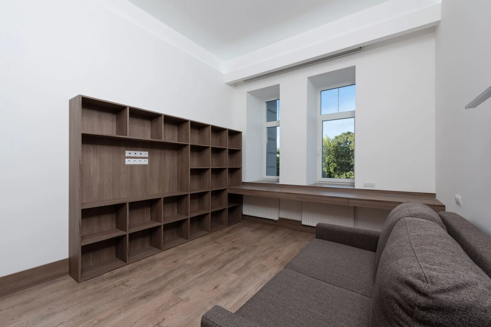 An empty living room with a sofa and a window