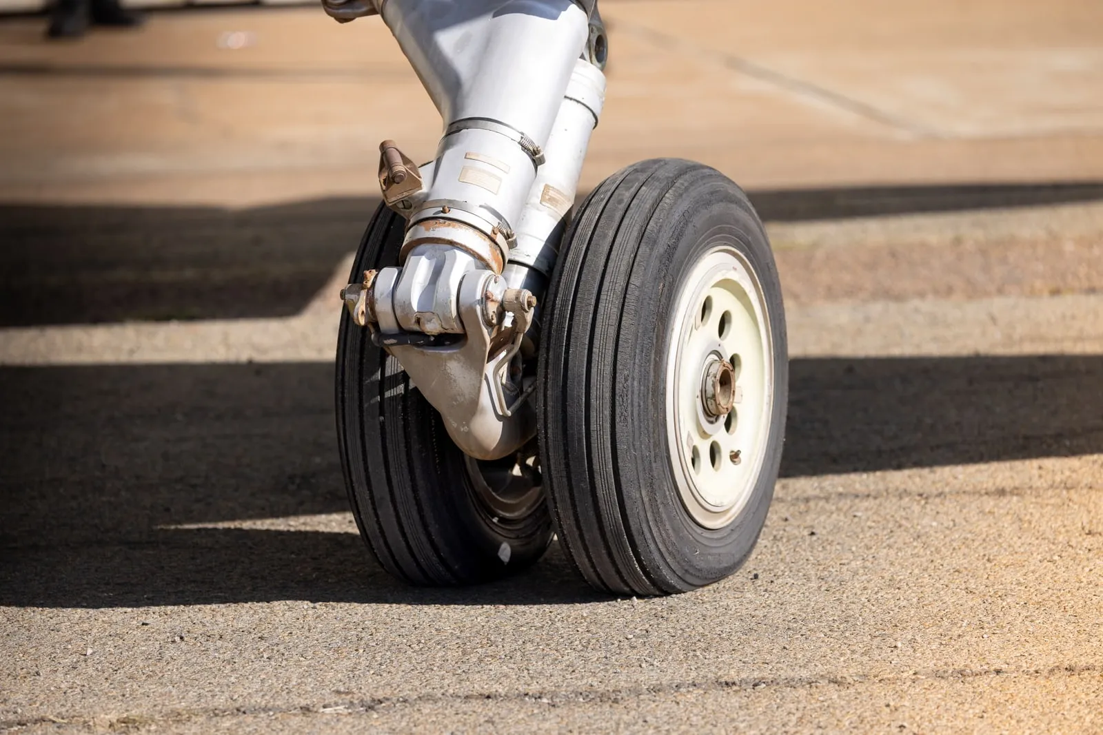 The landing gear of a parked aircraft on the tarmac