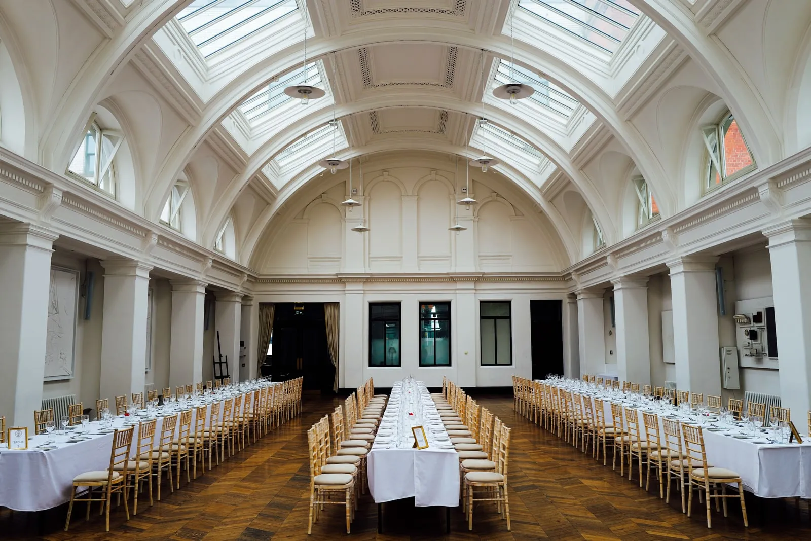 De longues tables de banquet dressées pour le dîner dans une salle claire