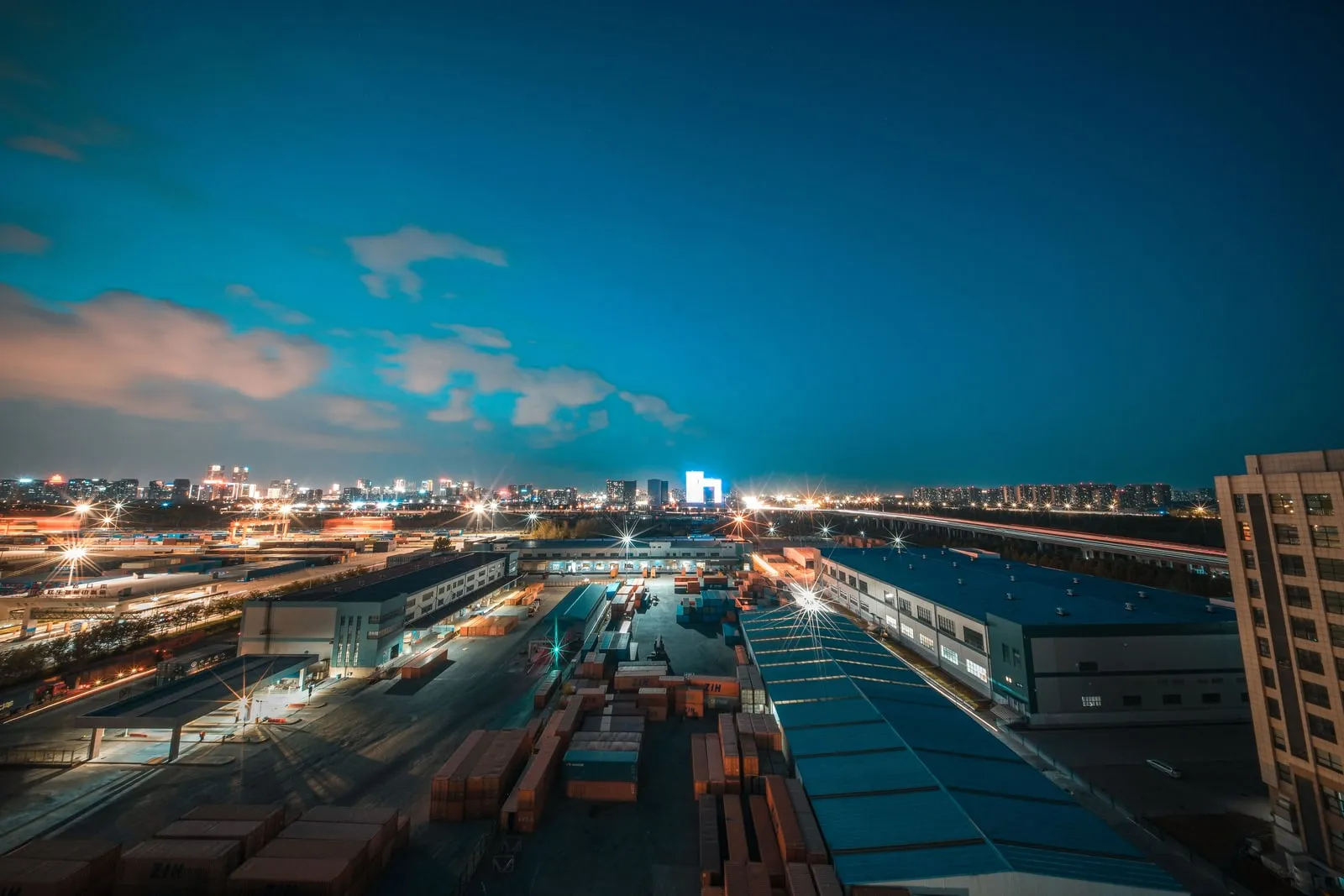 An elevated view of warehouses and container yards at dusk