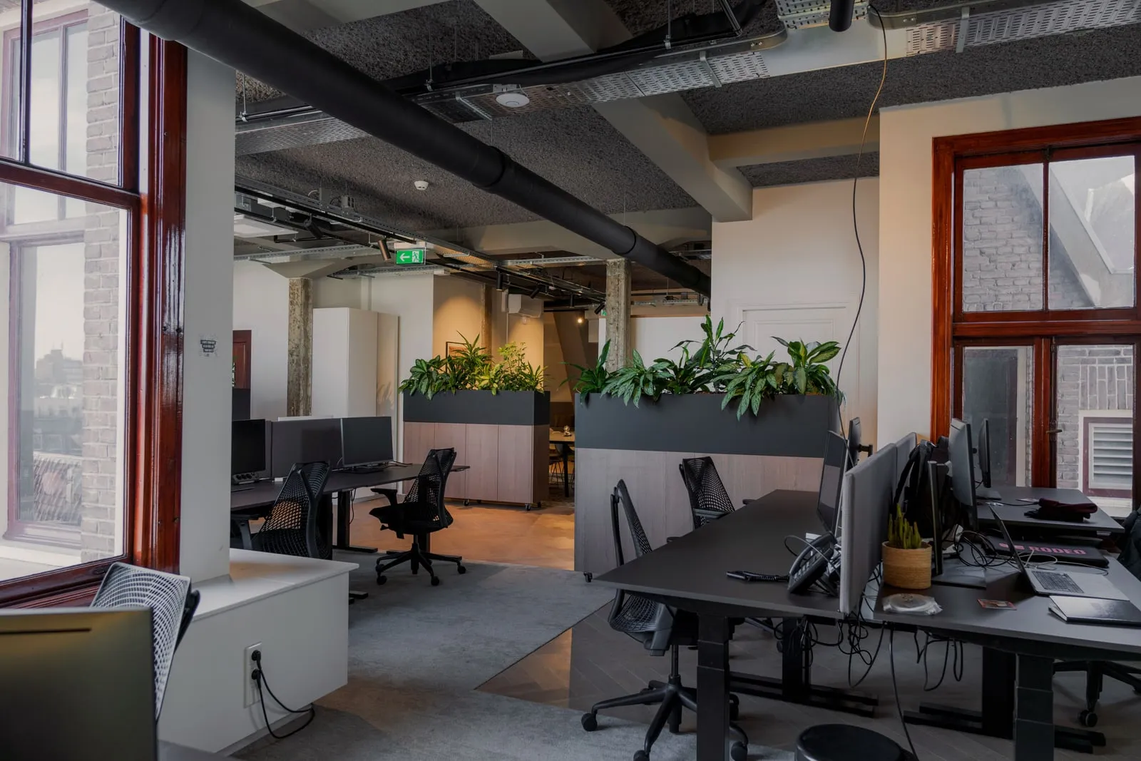 An open-plan office with rows of desks and monitors