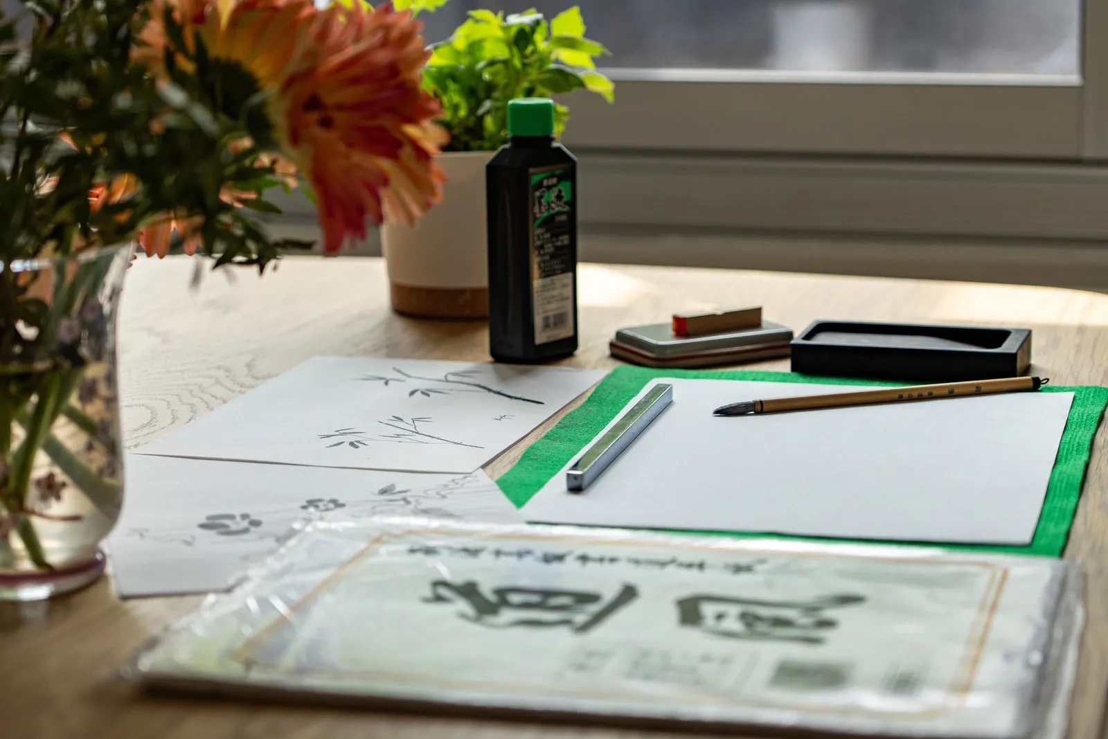 An artist's desk with ink bottles, brushes and paper