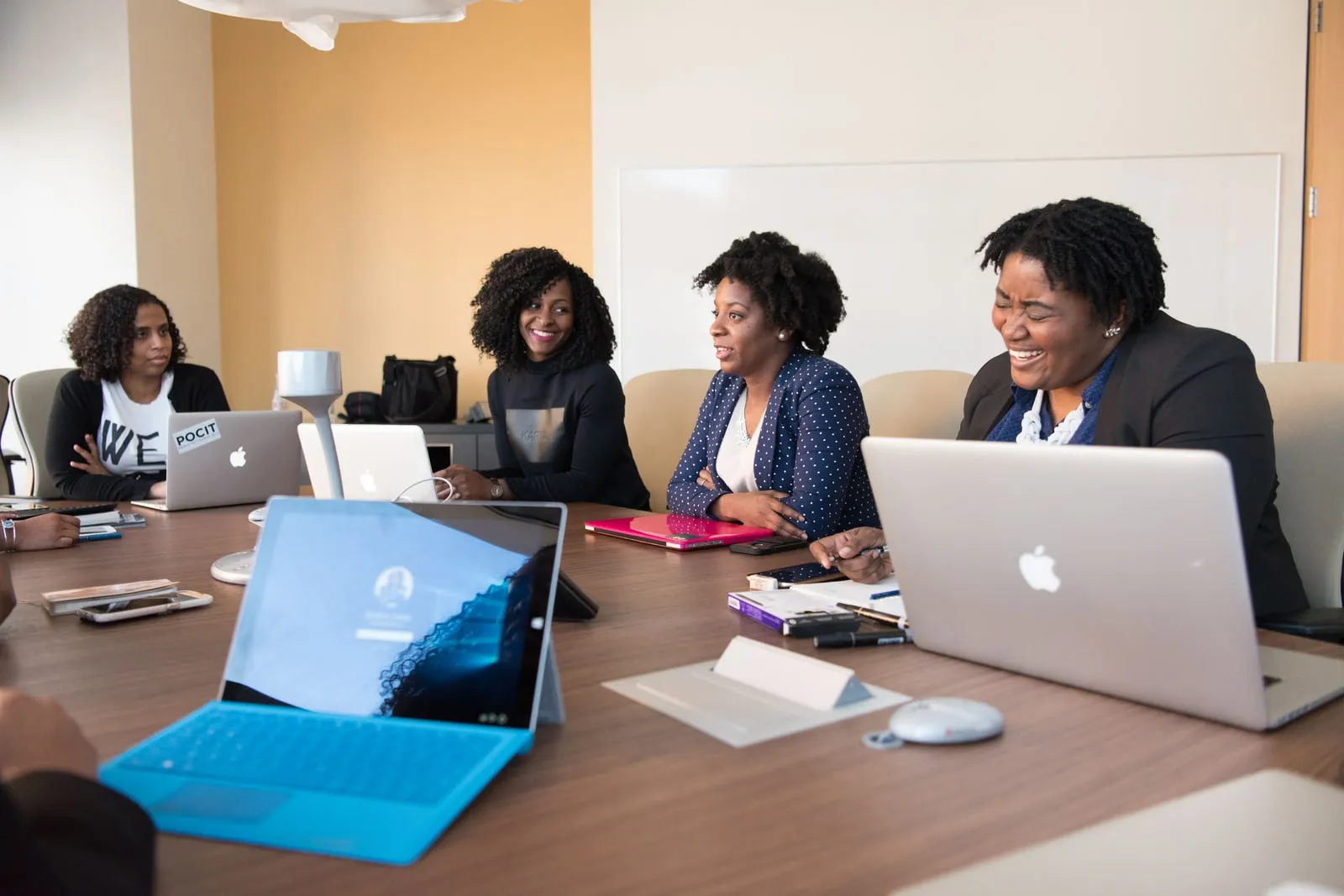 Colleagues meeting around a table with open laptops