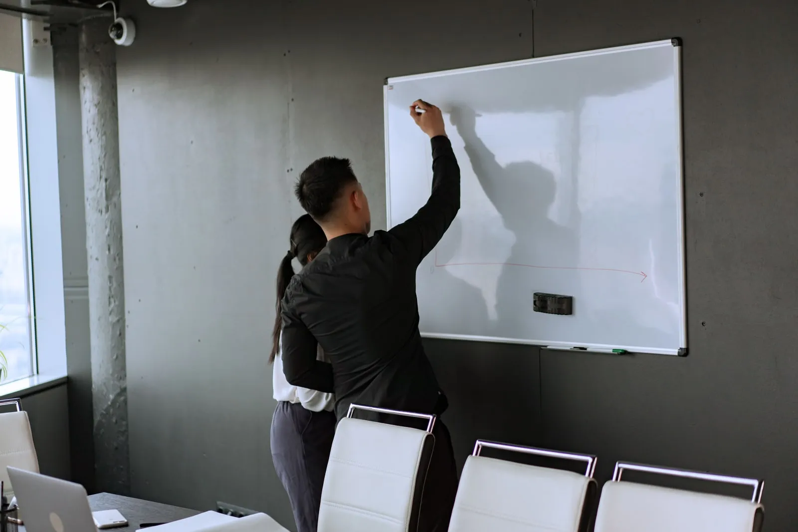 Researchers writing on a whiteboard in a meeting room