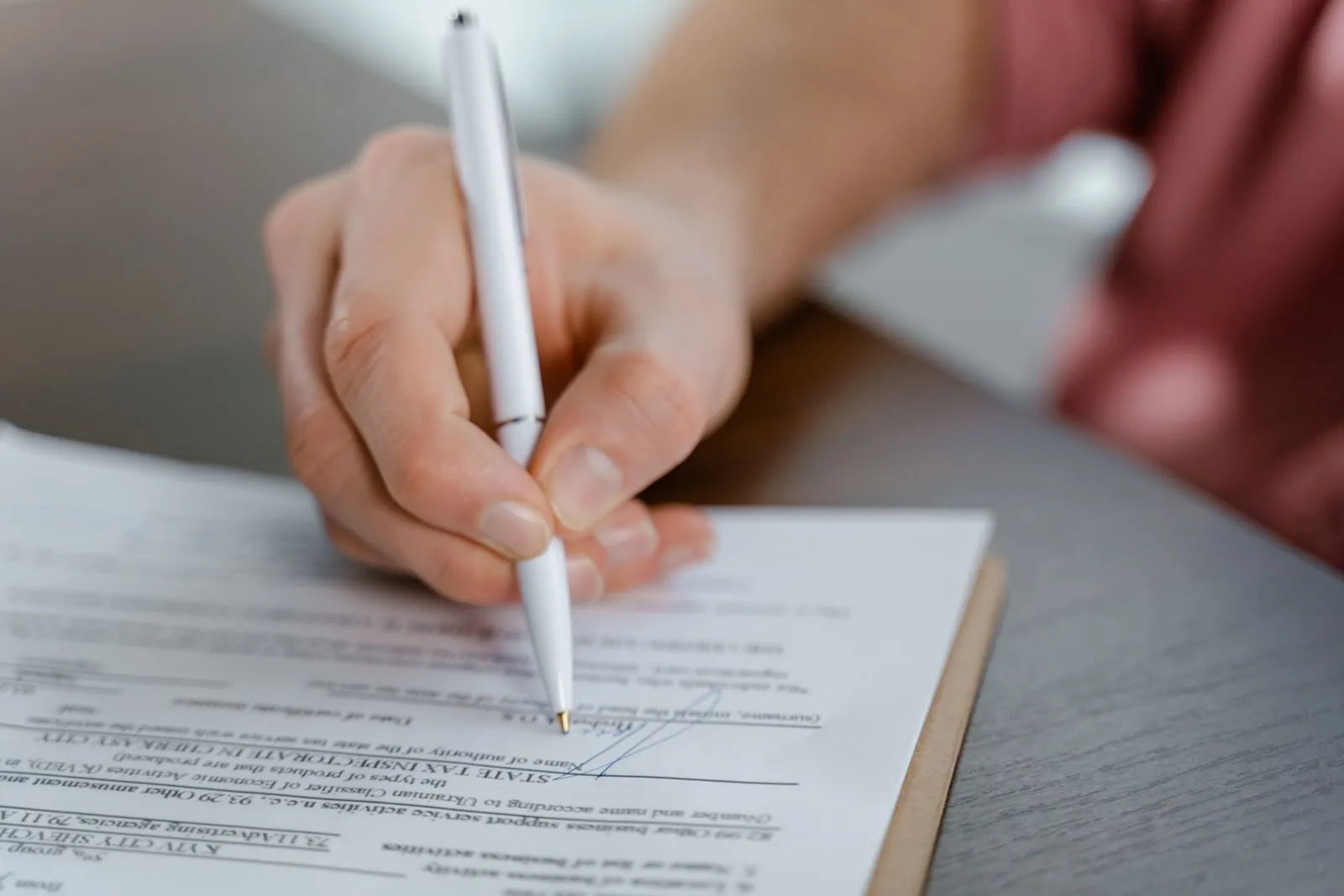 A pen signing a printed contract