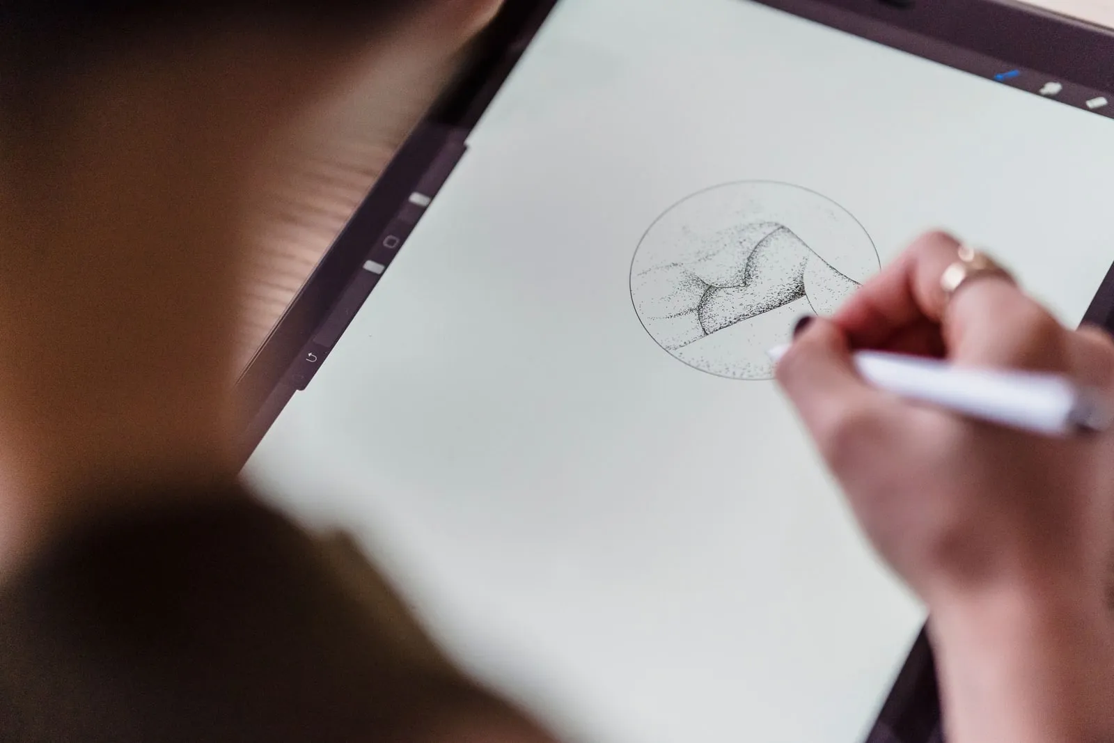 A person sketching on a drawing tablet