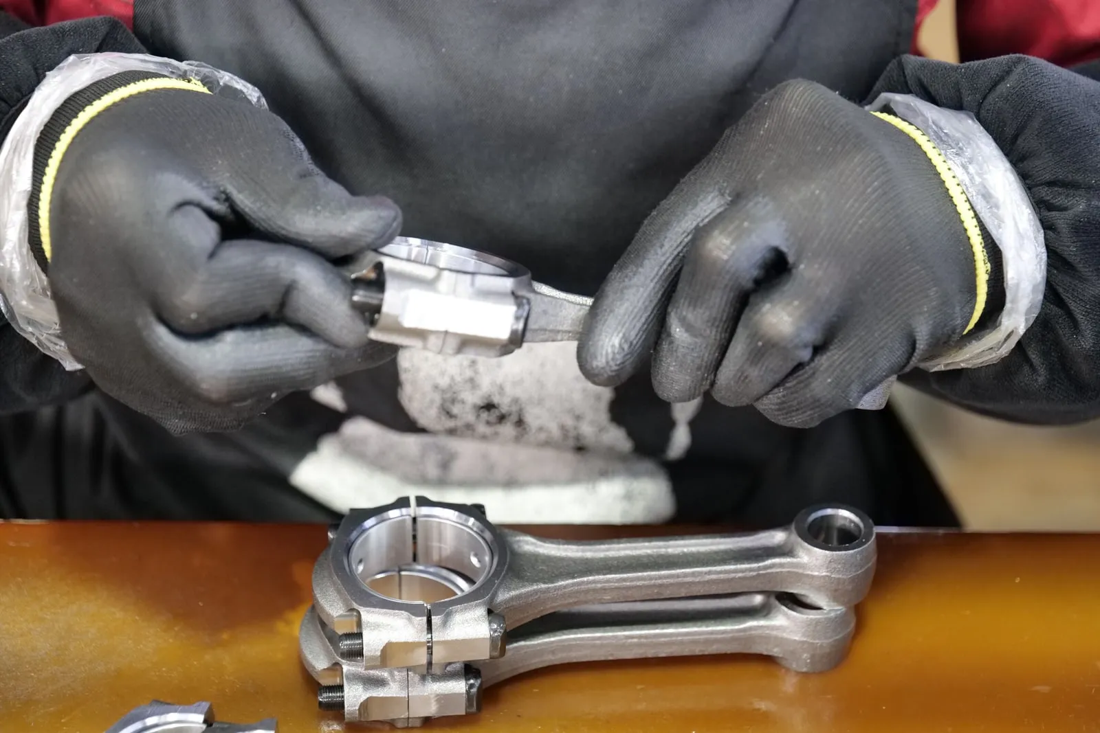 A worker inspecting metal parts in a machine shop