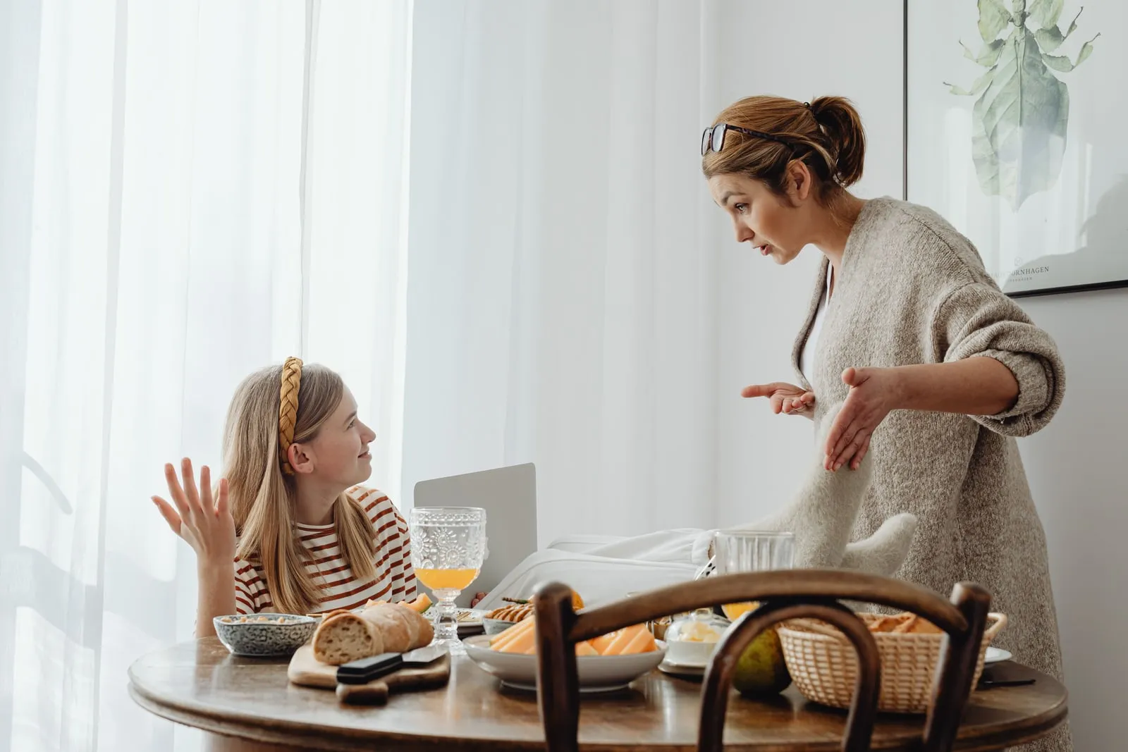 A parent and a teenager talking in a kitchen