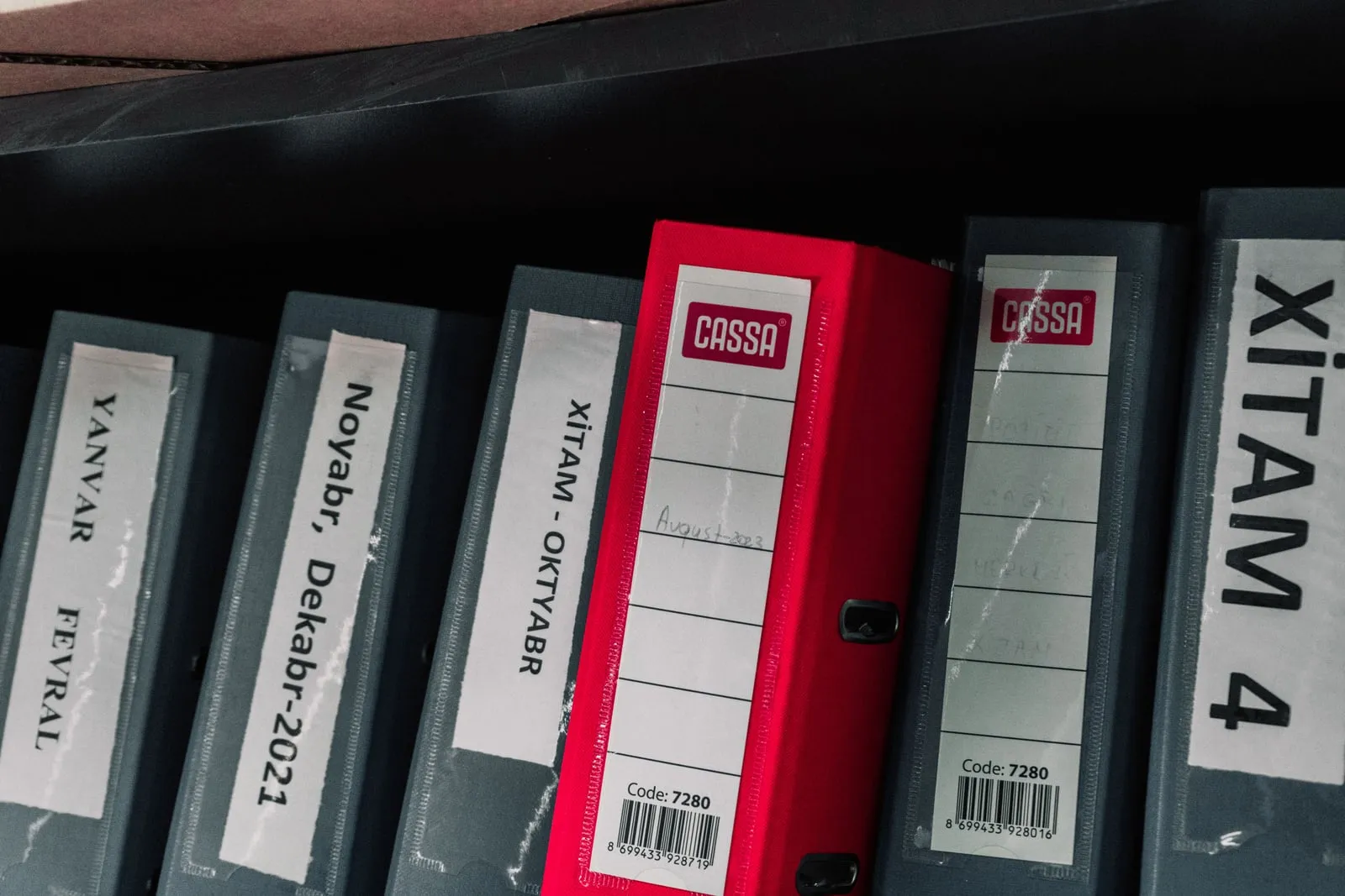 Stacked paper files and folders on an office shelf