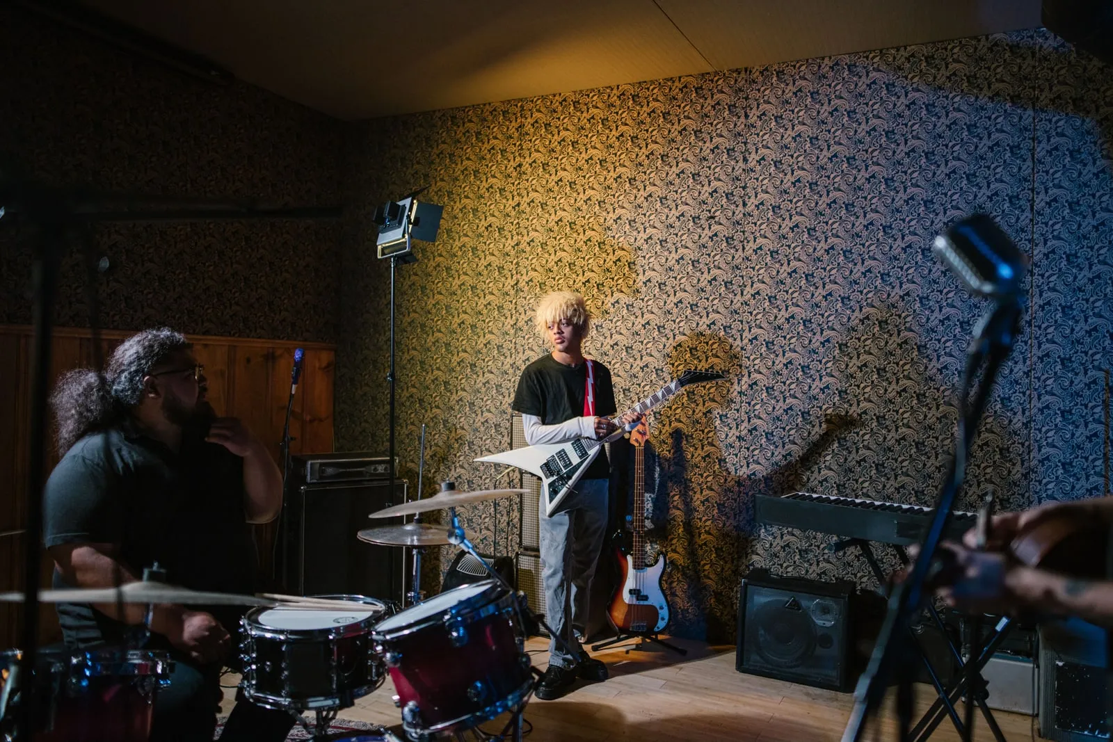 A musician playing an electric guitar in a rehearsal room
