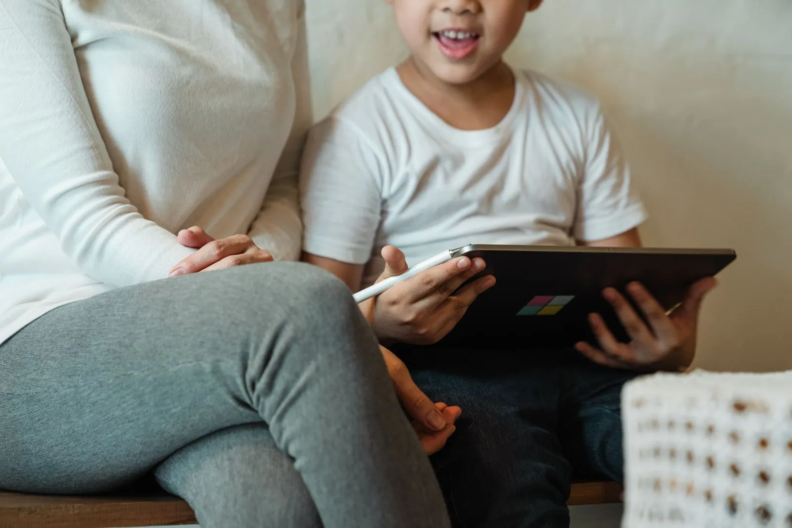 A parent and child using a tablet together at home