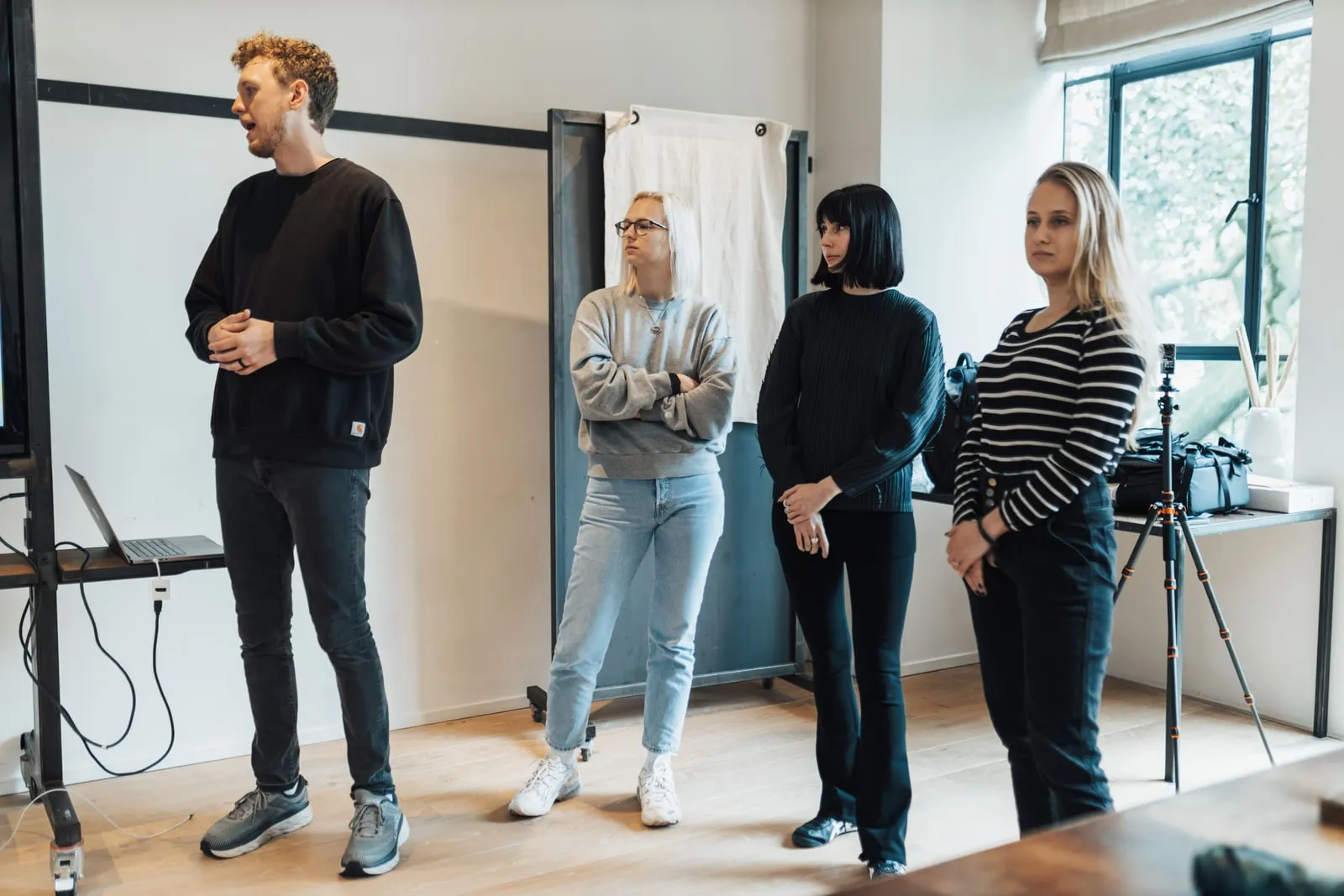 Four people standing together in a studio