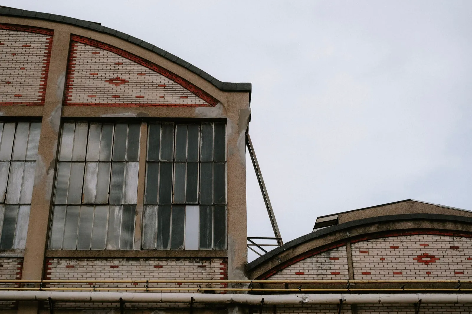 The brick facade and arched roofs of an old industrial hall