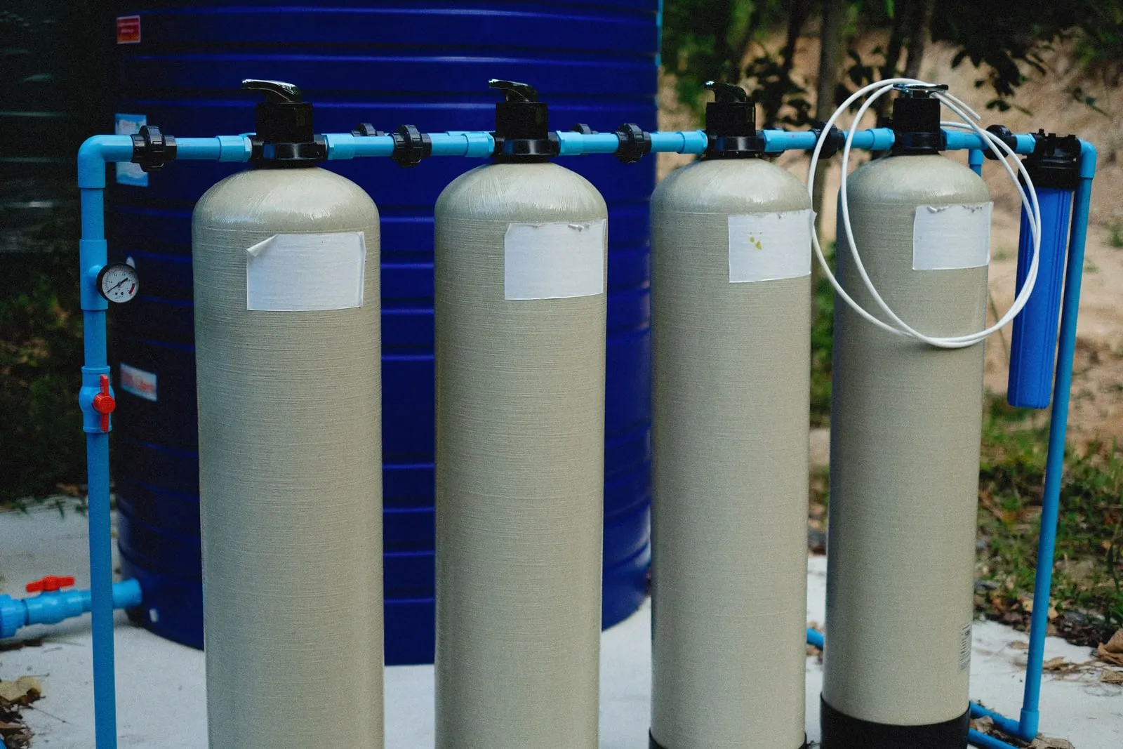 Filtration cylinders and valves beside a water storage tank