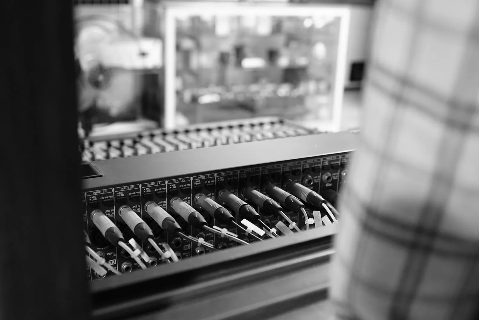Cables plugged into the numbered input channels of an audio mixing console