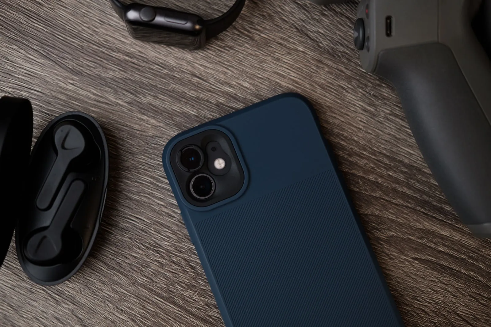 A smartphone and an earphone case on a wooden table