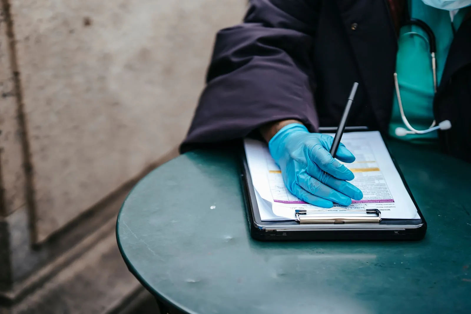 A clinician writing notes on a clipboard