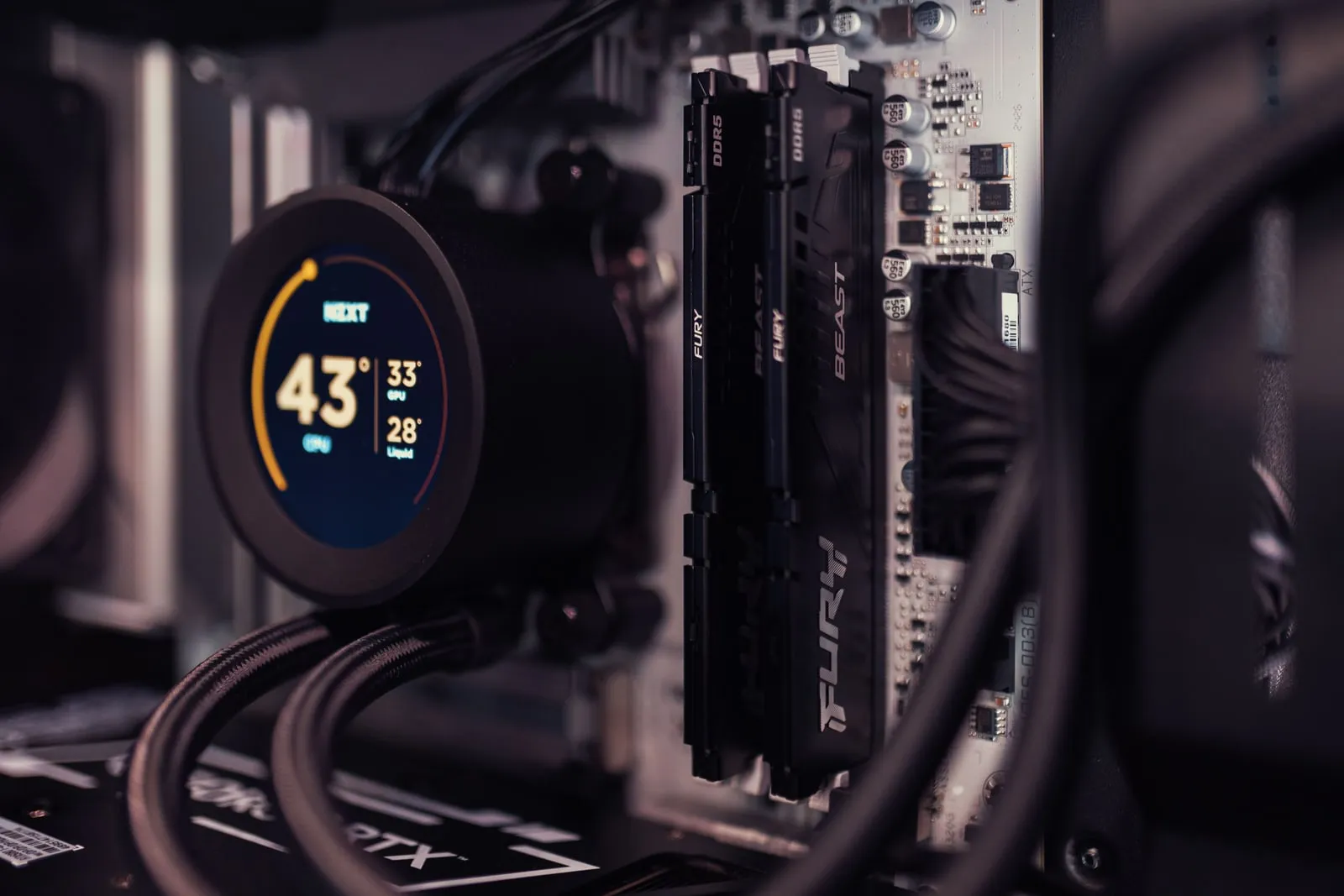 The inside of a desktop computer, showing memory modules and a cooler display
