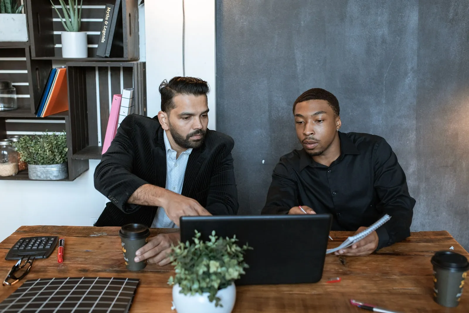 Colleagues looking at a laptop together at a table